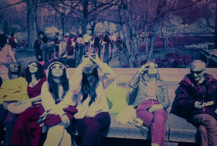 Menschen beobachten die Sonnenfinsternis am Südrand des Central Park, Manhattan. Belichtet auf Kodak EIR Infrarotfilm